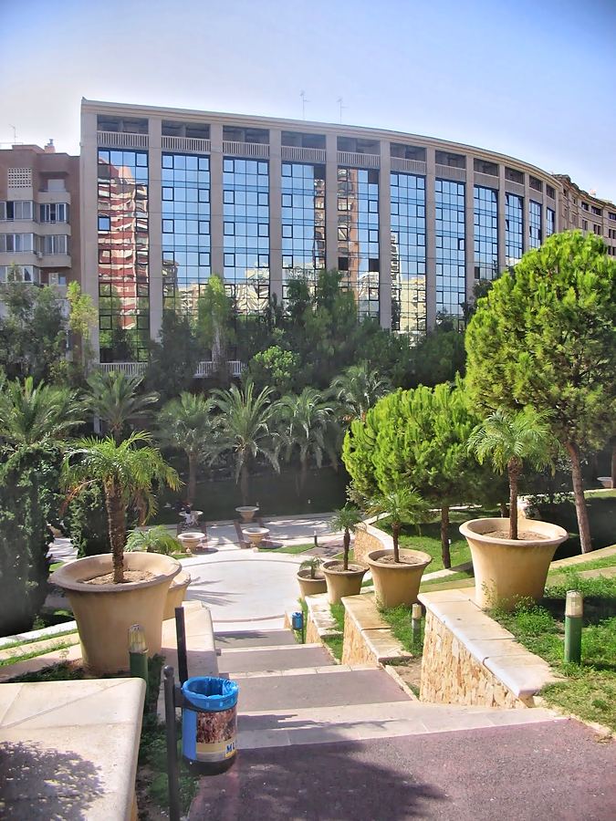 Escalinata ajardinada con maceteros que sube hacia el edificio