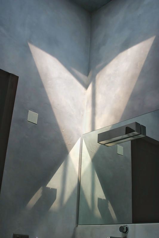 Juego de luz en forma de estrella sobre una pared gris