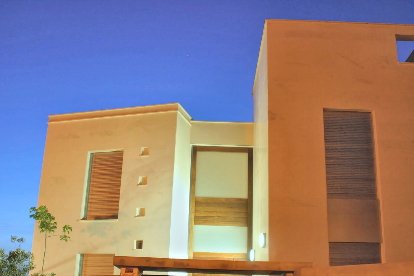 Fachada con luz del atardecer y celosías de madera