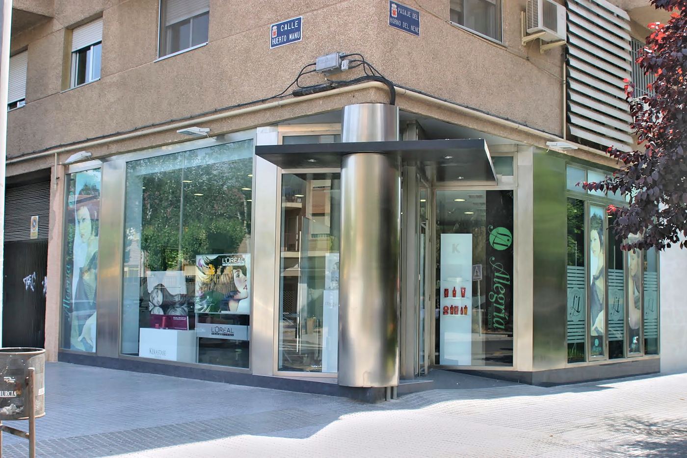 Fachada en esquina del local, con columna de acero inoxidable y escaparates